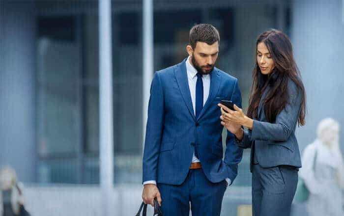 A man and woman looking at something on their phone.