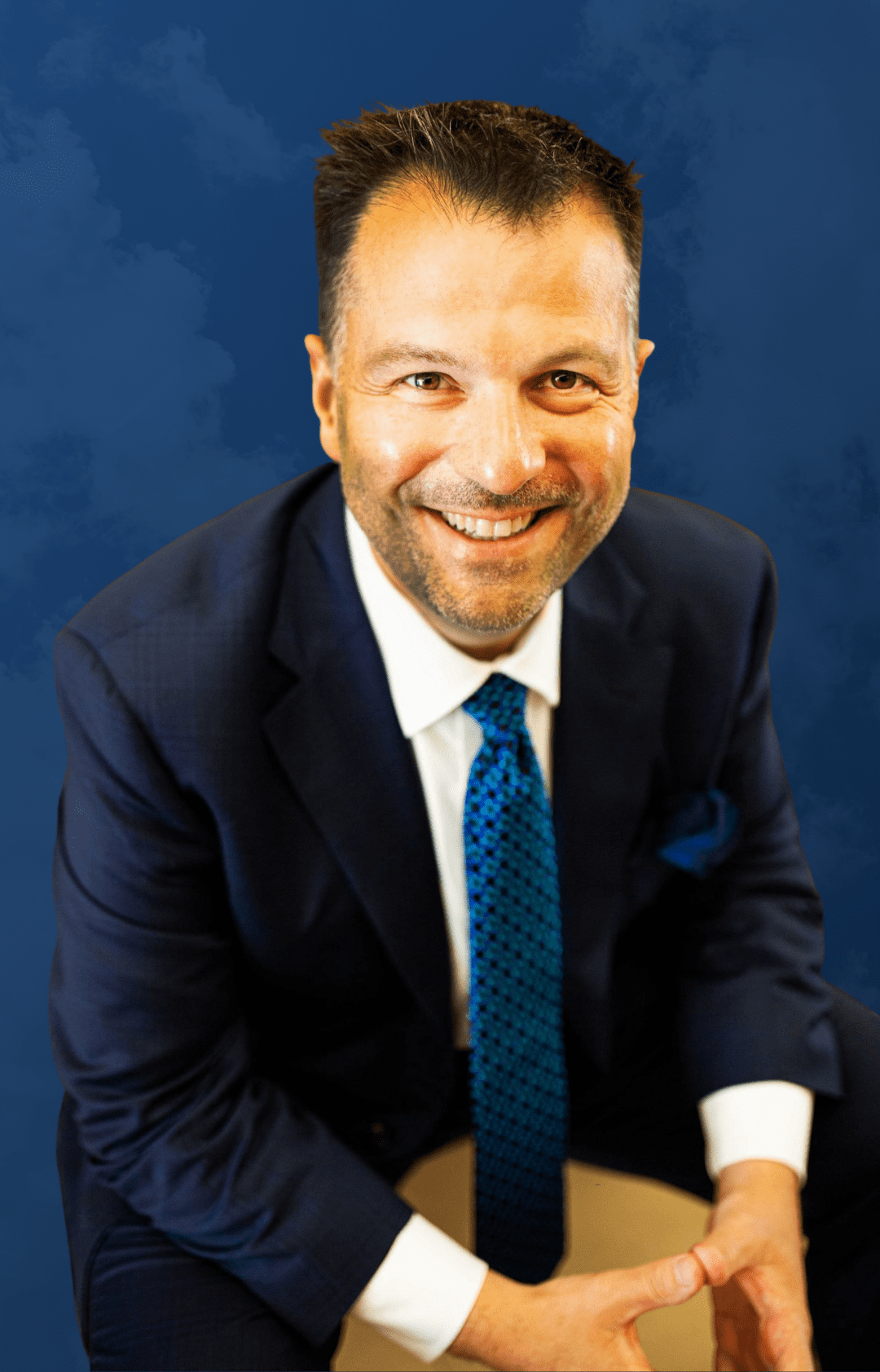 A man wearing a blue coat, smiling at camera